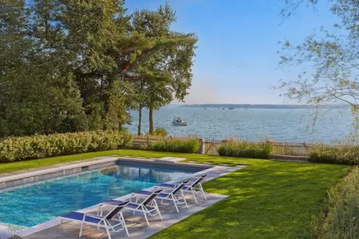 This Duxbury landscape pairs a stone pool terrace with layered coastal planting while preserving open water views.