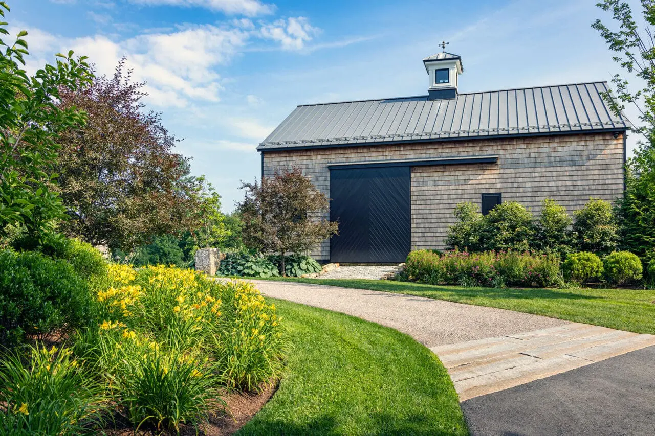 Carlisle, MA - Gravel paving and restrained planting complement the barn’s metal roof, maintaining a cohesive rural aesthetic. Photo: Warren Patterson