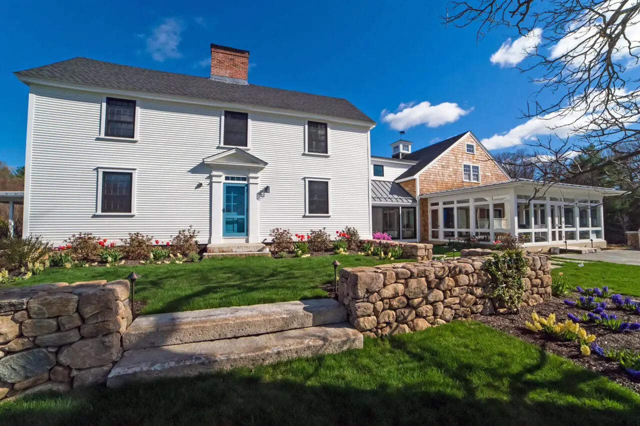 Carlisle, MA - Fieldstone walls and granite steps define the main entry, establishing formality and durability at the home’s threshold.