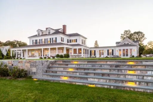 A natural stone pool terrace overlooking the coastal landscape in Duxbury, MA, where carefully layered plantings and elegant hardscape create a refined outdoor living space suited to South Shore properties.