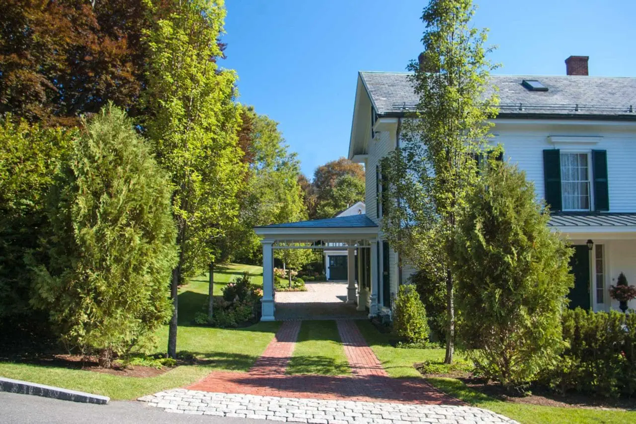 Belmont, MA - Large Chanticleer Flowering Pear trees mark the entrance to the driveway as cobblestone and brick usher a driver into the carport.
