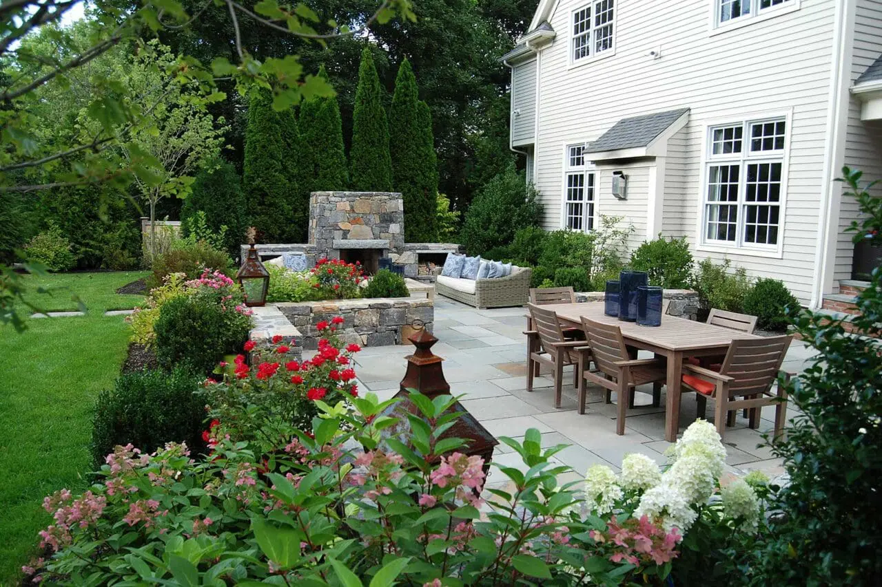 Backyard patio dining area with fireplace, offering a comfortable setting for outdoor meals and evening gatherings.
