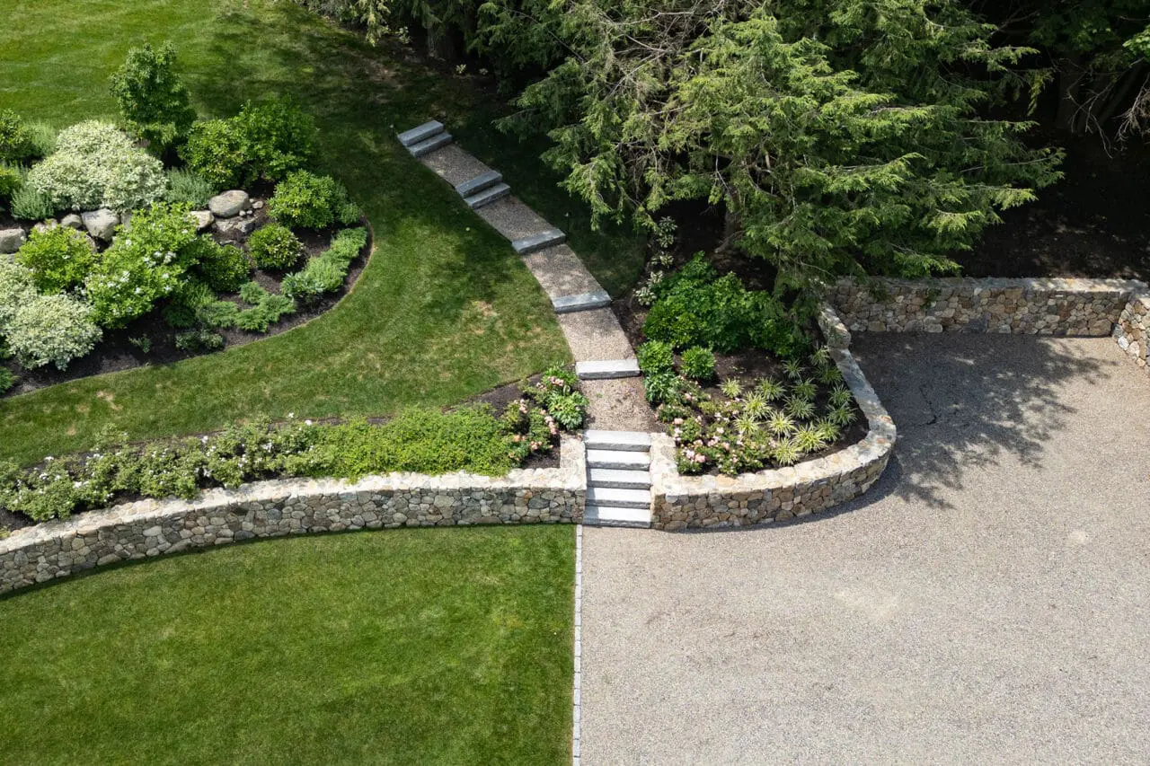 Gravel garden path curves alongside bluestone steps and retaining walls, managing grade with a natural feel.