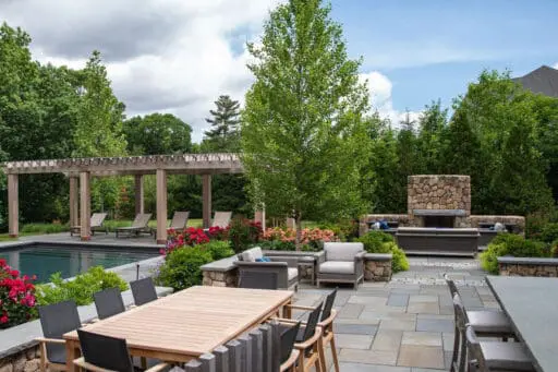Luxury pool terrace with pergola, outdoor fireplace, and lounge zones adds resort‑style comfort and refined details for summer relaxation.