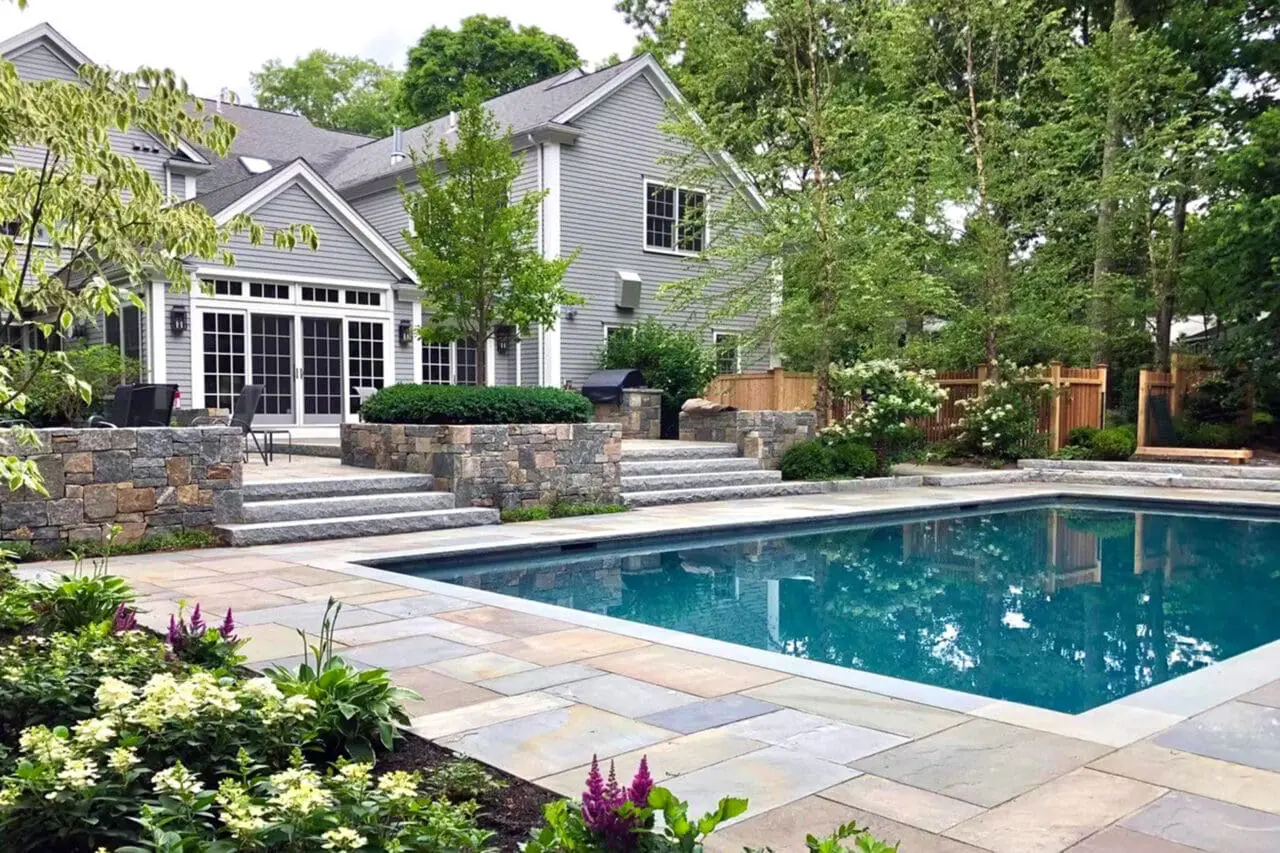 This modern rectangular pool features cut stone walls and crisp edges, using strong geometry and minimal detailing to complement contemporary architecture in Newton.