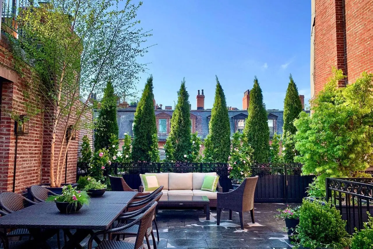 Urban rooftop plantings and vertical screening soften hard edges while blocking neighboring views to create a more secluded outdoor retreat.