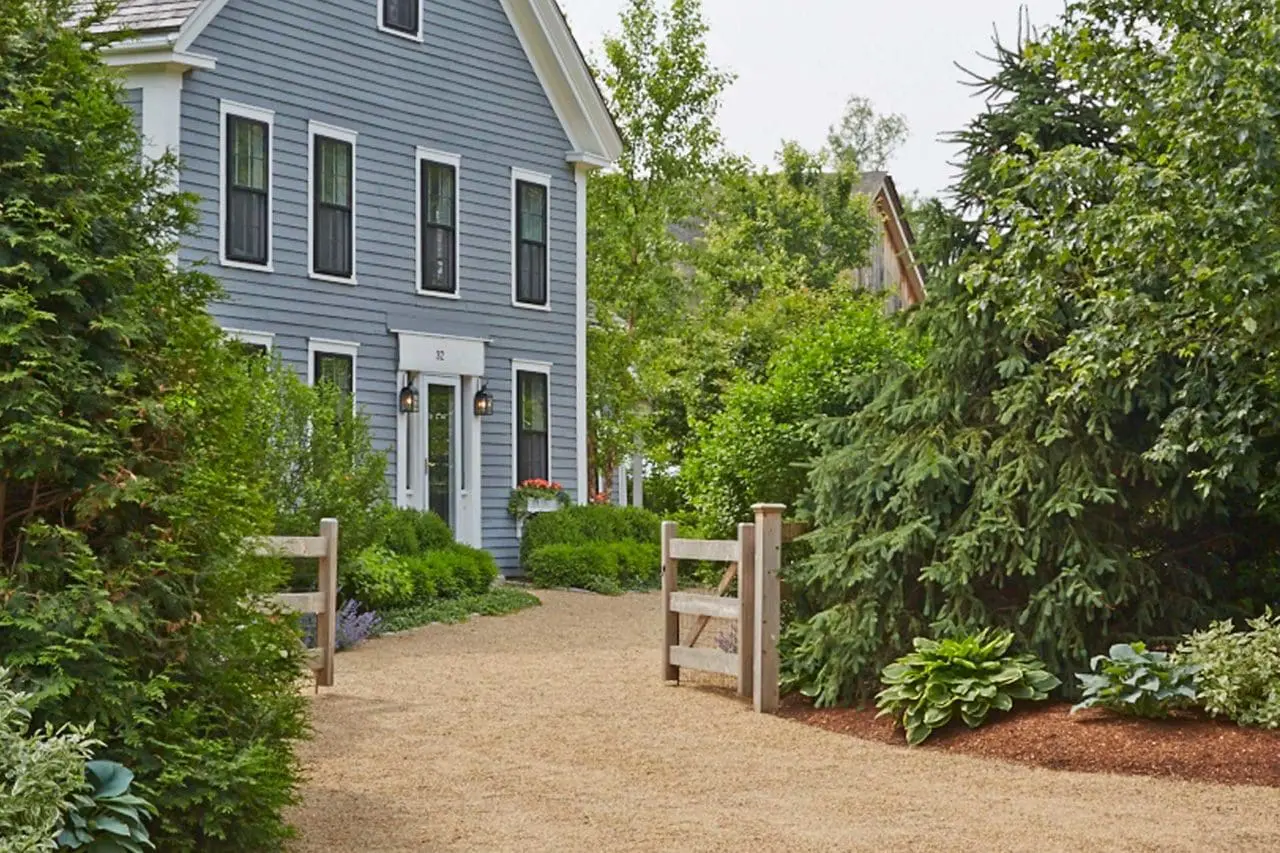 Wayland, MA - The winding pea stone driveway greets guests. A wooden fence and gates allow the owner's to keep their dogs close.