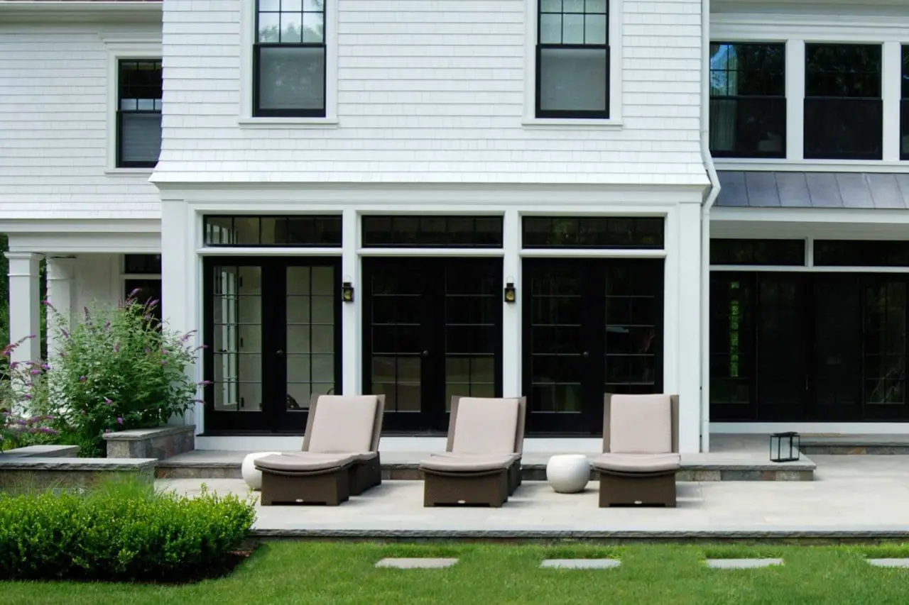 Weston, MA - A contemporary stone patio in Weston creates a comfortable outdoor living area, with clean-lined furnishings and restrained planting complementing the home’s modern landscape design.