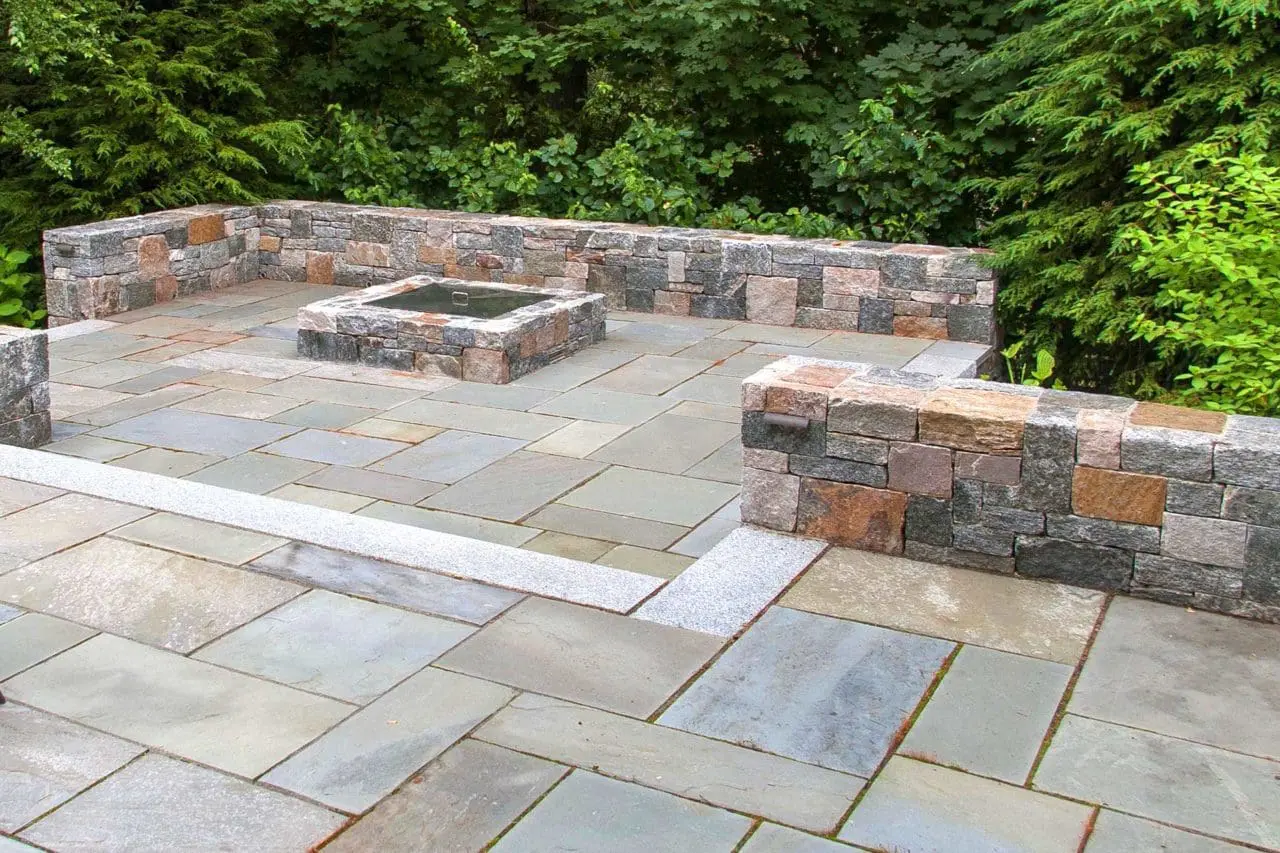 Wellesley, MA - Bluestone terraces and firepit supported by Corinthian granite seating walls provide outdoor gathering areas.
