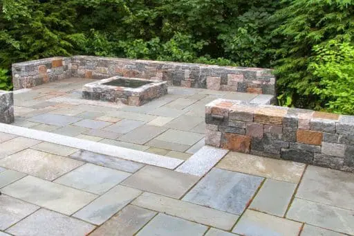 Wellesley, MA - Bluestone terraces and firepit supported by Corinthian granite seating walls provide outdoor gathering areas.