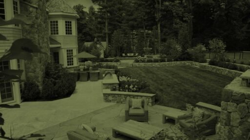 Wellesley, MA - A thoughtfully designed landscape with stone terraces, lawn, layered plantings, and inviting outdoor living spaces.