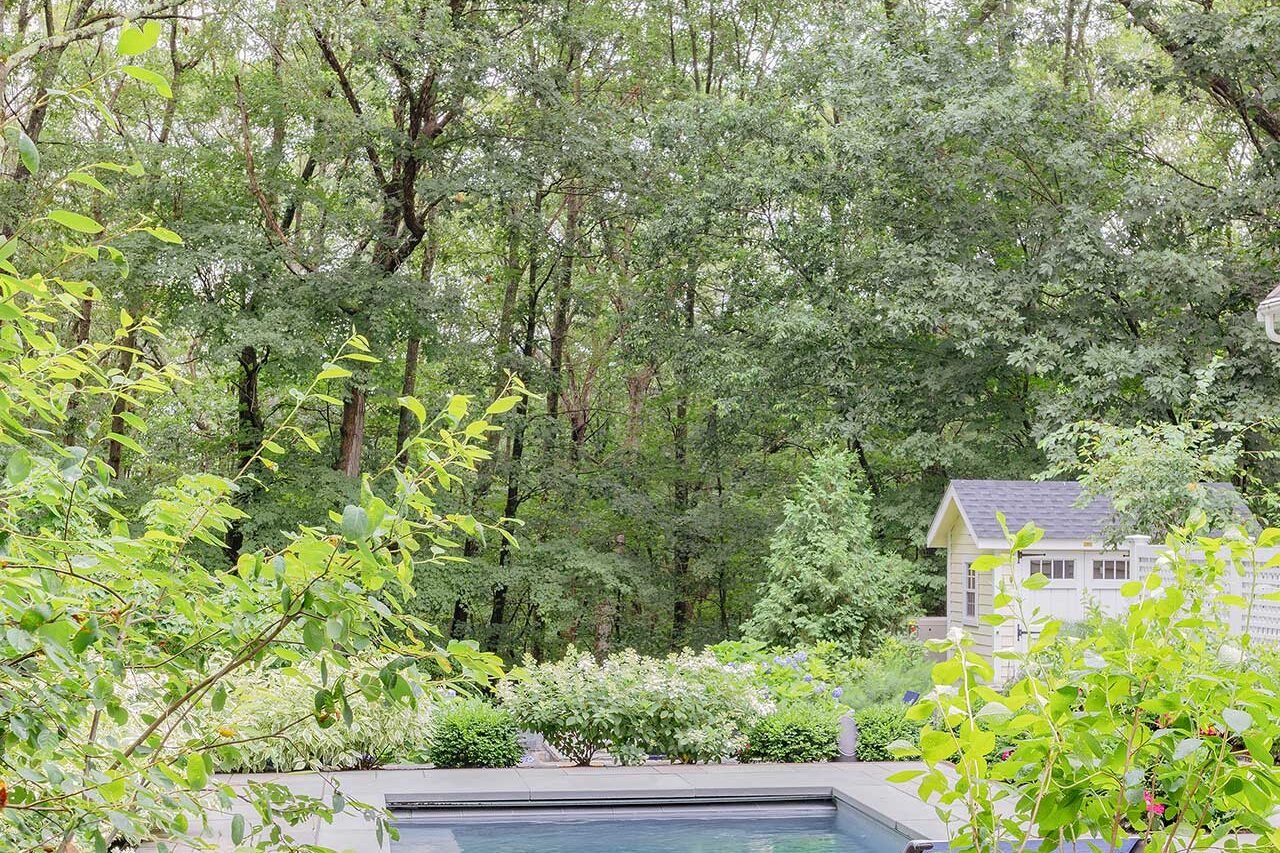 Wellesley, MA - Framed by soft planting and woodland views, the pool lounge terrace offers a quiet outdoor room designed for relaxation and seasonal enjoyment. photo credit: Michael J Lee