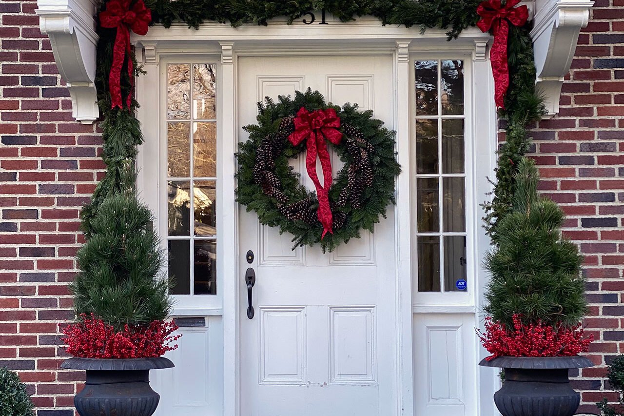 A holiday wreath enhances this colonial-style entry, reinforcing symmetry and adding warmth without overpowering the façade.
