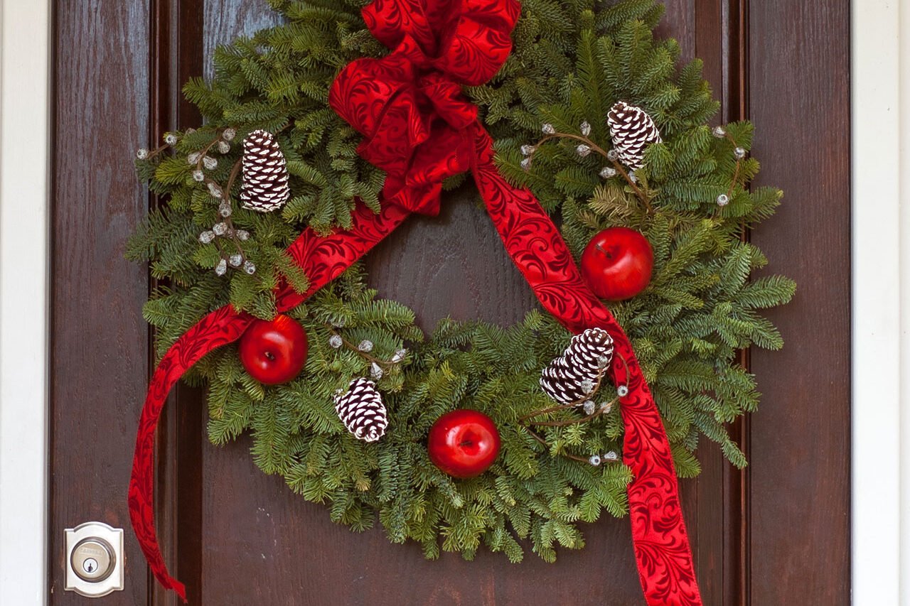 Traditional evergreen wreath finished with a red ribbon offers timeless curb appeal and a welcoming holiday accent this Boston home.