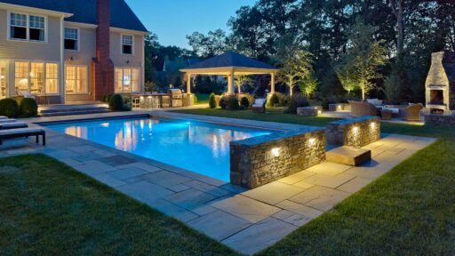Wilmington, MA - Landscape lighting adds warmth, depth, and definition, making the pool, stonework, and surrounding trees more inviting after dark.