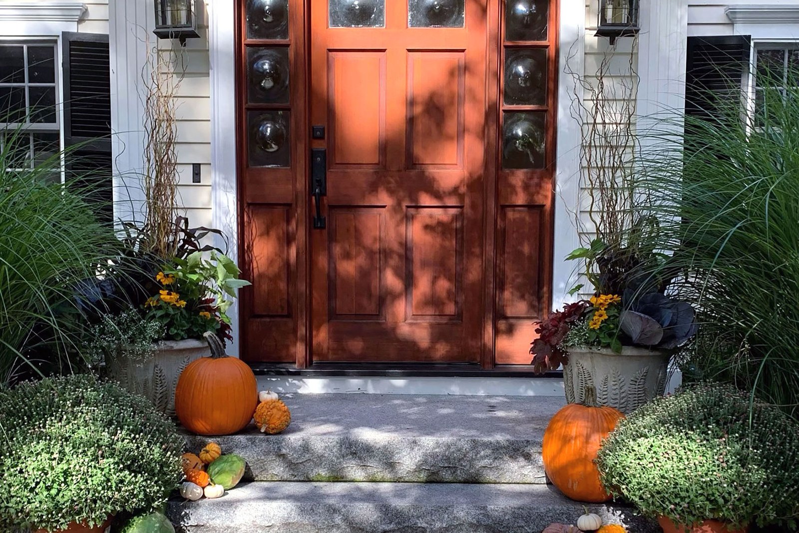 Brookline, MA - Colonial entry styled with pumpkins, planters, and fall florals balances tradition and color, enhancing curb appeal through seasonal accents.