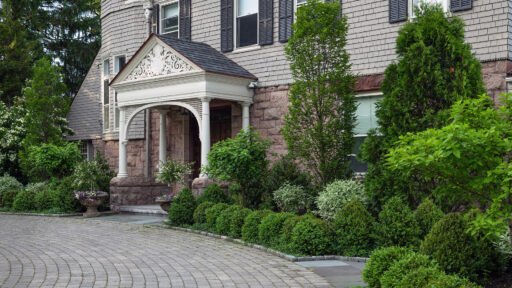 Brookline, MA - Mixed foundation shrubs surround this historic entry, balancing evergreen mass with varied textures to complement architecture and create a welcoming approach.