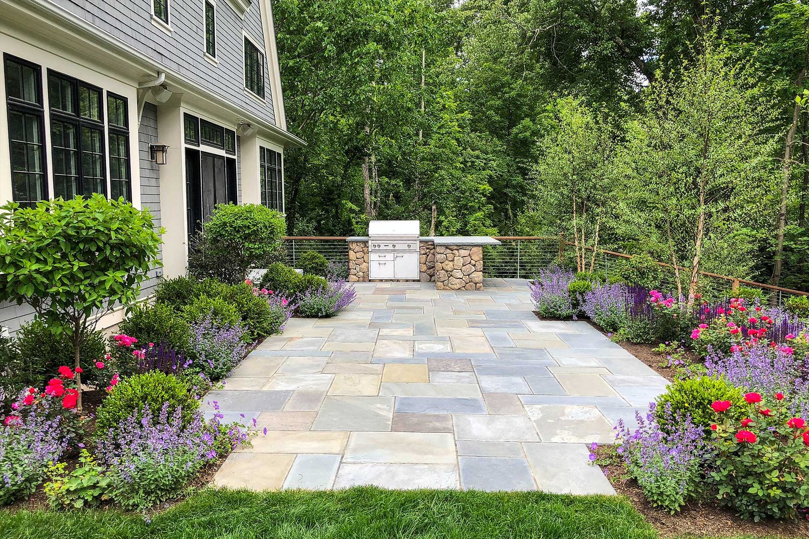 Weston patio with outdoor kitchen and flowering borders