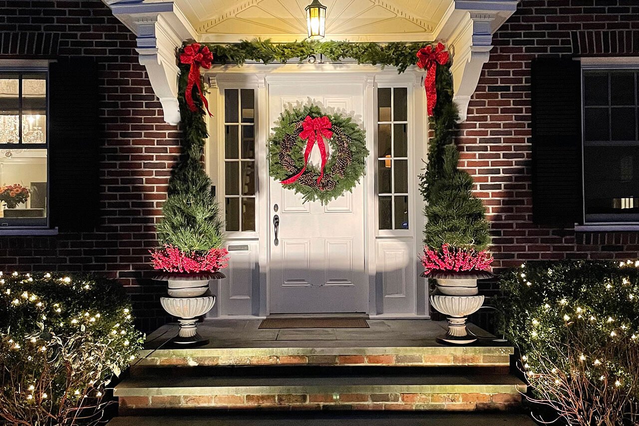 Classic Brookline front entry decorated with an evergreen wreath and seasonal planters filled with winter greenery.